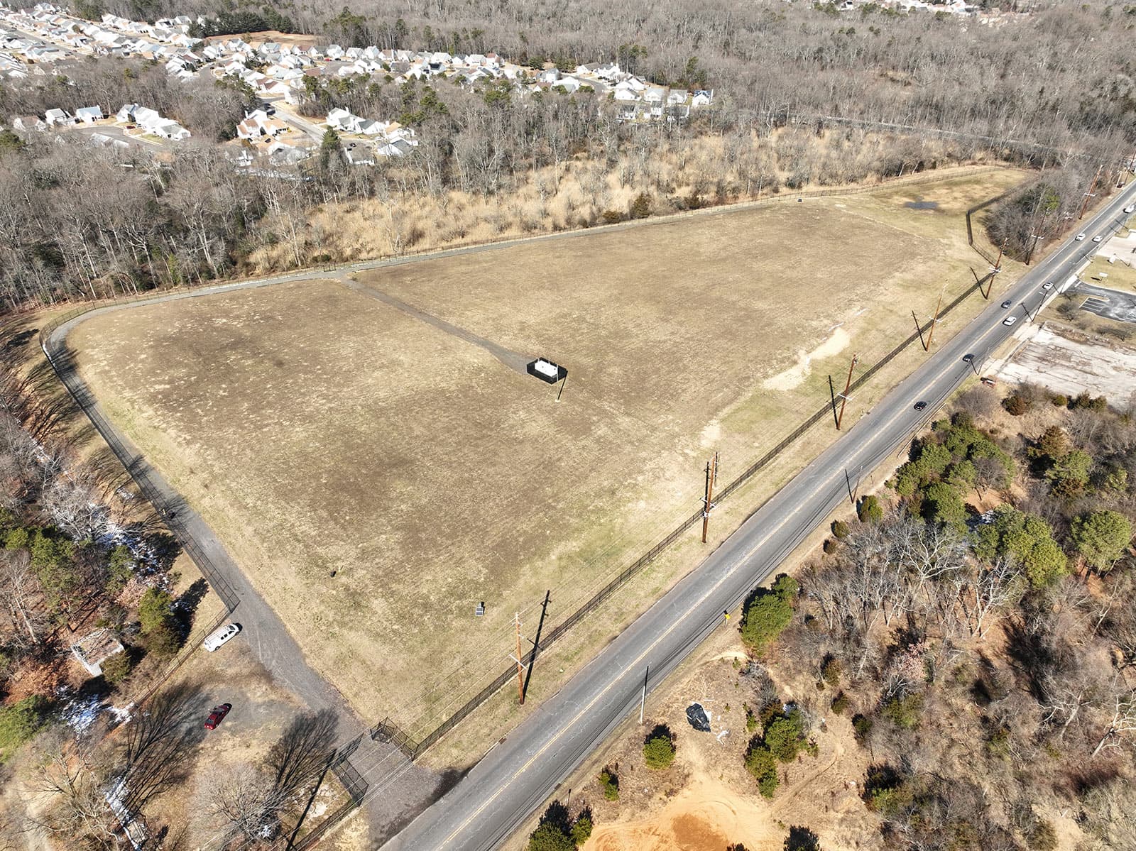 An aerial view of a large vacant lot with a road running through it